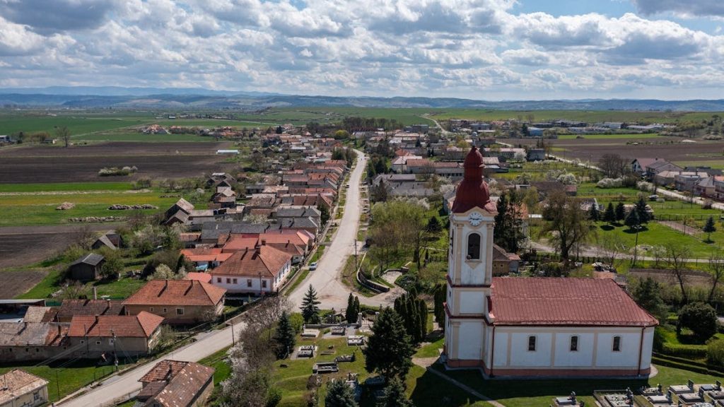 Scenic aerial view of Chanava village in Slovakia with church, fields, and rural landscape on a sunny day.