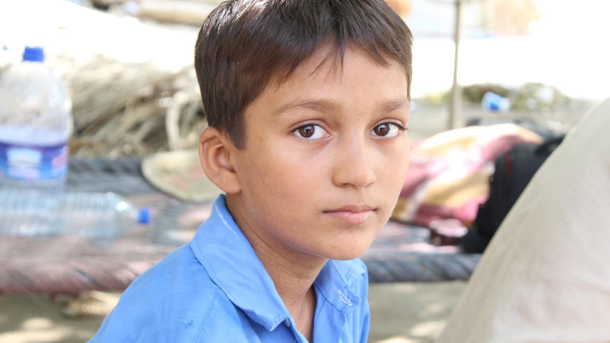 Close-up portrait of a young boy in Mehmood Kot, showcasing authentic rural life.